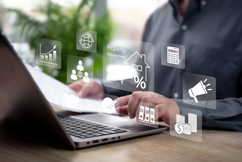 Person working on a laptop with floating digital icons representing property, growth charts and investment management for a Port Stephens client