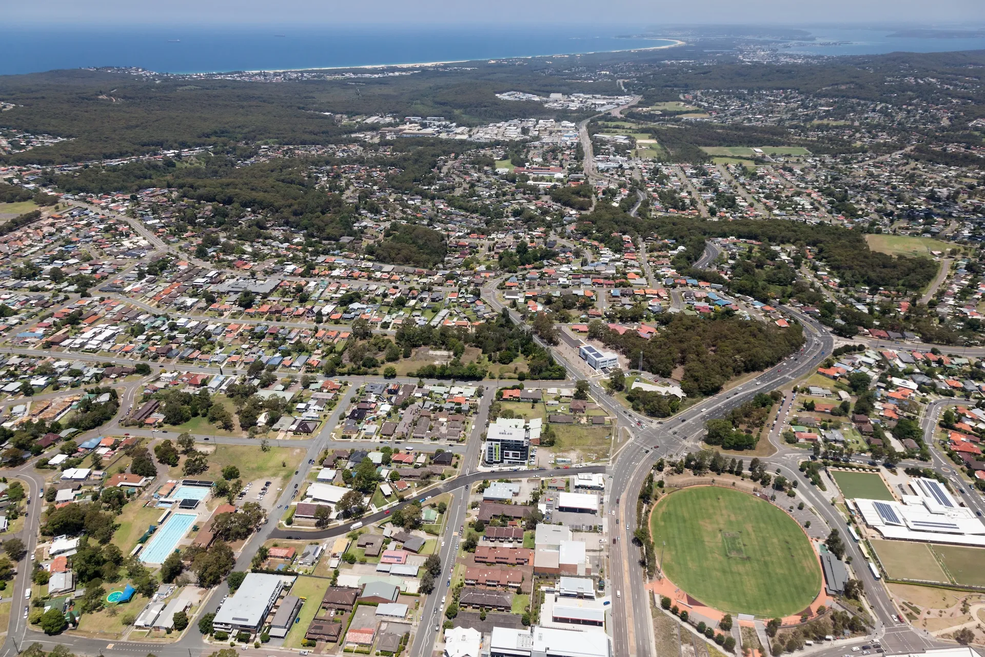 Aerial view of Lake Macquarie residential streets with the lake and coastline in the distance