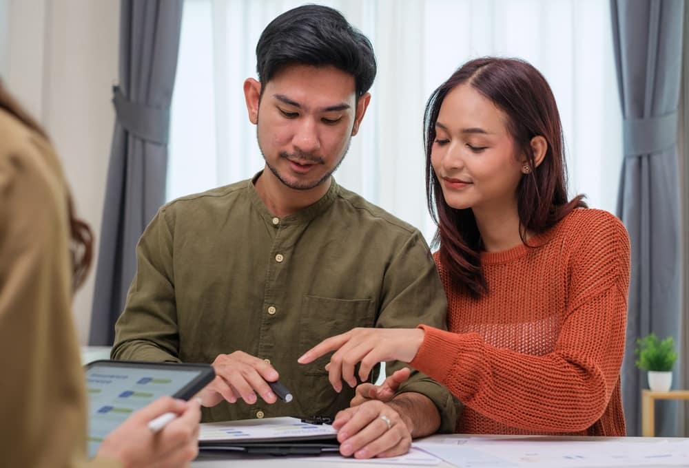 Young couple from the Hunter region reviewing financial planning documents and a tablet with their Newburn Wealth Advisory adviser