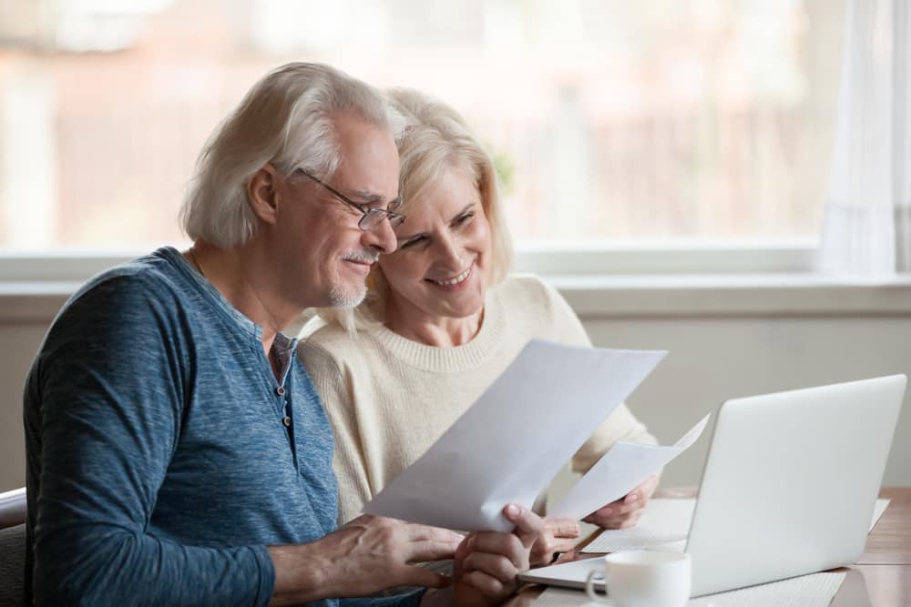 Smiling retired Hunter region couple reading a retirement planning document together
